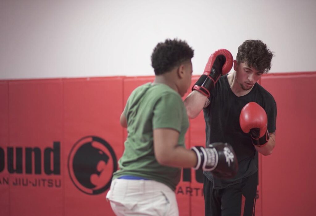 Two martial arts students sparring with punching gloves